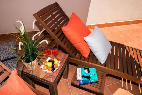 a couch with orange and white pillows and a table at Le Dimore Del Re in Trani