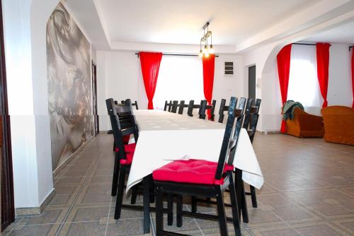 a dining room with a white table and chairs at Pensiunea Royal in Ranca