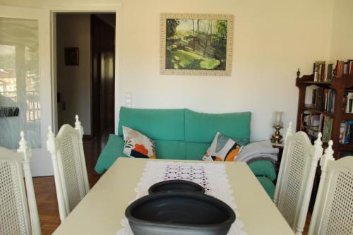 a dining room with a table and a green couch at marsupilami in Pobla de Segur