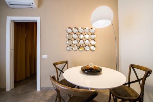 a dining room with a white table and chairs at Le Dimore Del Re in Trani