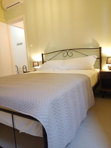 a bedroom with a large bed with a white comforter at Marw's home in Nafplio