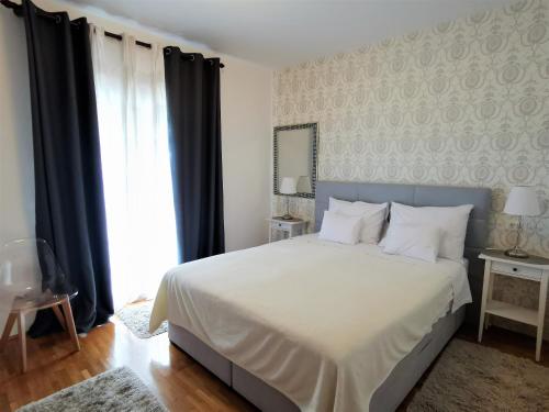 a bedroom with a white bed and a large window at Duplex Maria Di, Free Parking, Sea View in Dubrovnik
