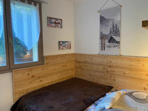 Zimmer mit einem Bett und einem Fenster in der Unterkunft Appartement rez de jardin expo sud in Saint-Gervais-les-Bains