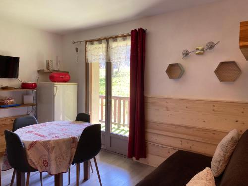 une salle à manger avec une table et une fenêtre dans l'établissement Appartement lumineux et cosy en rez de jardin, à Saint-Gervais-les-Bains