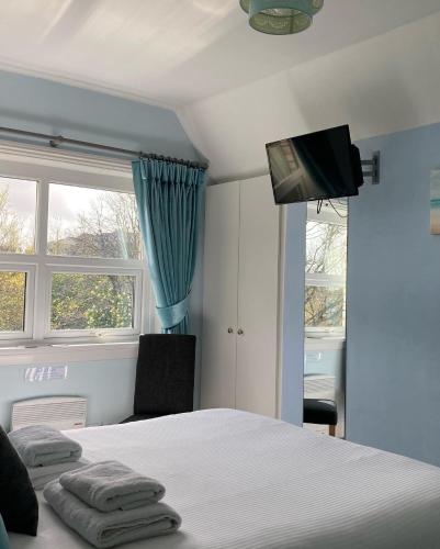 a bedroom with a bed and a tv on the ceiling at The Wentworth Guest House in Paignton
