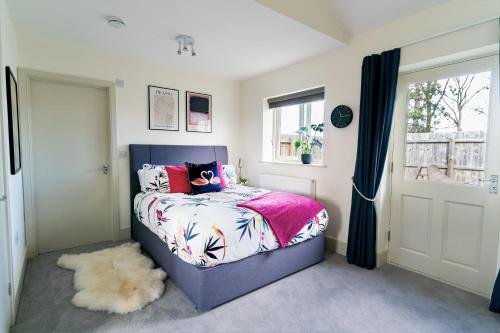a bedroom with a bed and a window at Chestnut Cottage at Gravel Farm in Stretham