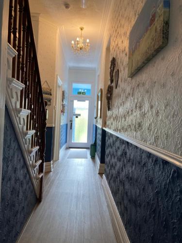 a hallway with a staircase and a chandelier at The Wentworth Guest House in Paignton