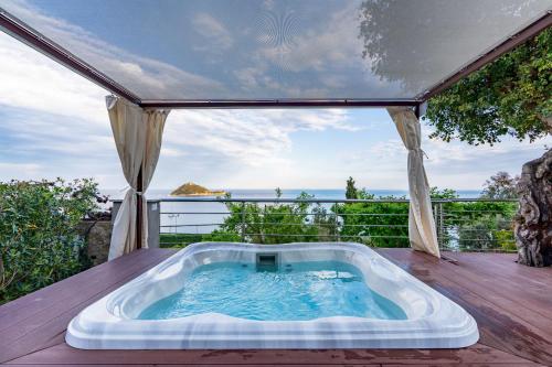 a hot tub on a deck with a view of the ocean at Baba Residences in Alassio