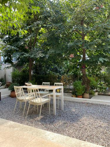a white table and chairs sitting next to a tree at Agrinio ART Suites in Agrinio