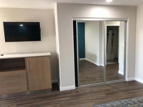 a living room with a television and a sliding glass door at Cali Inn in Carson