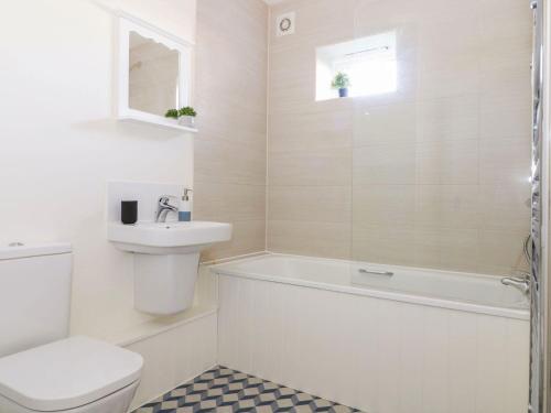 a bathroom with a toilet and a sink and a bath tub at Chestnut Cottage at Gravel Farm in Stretham