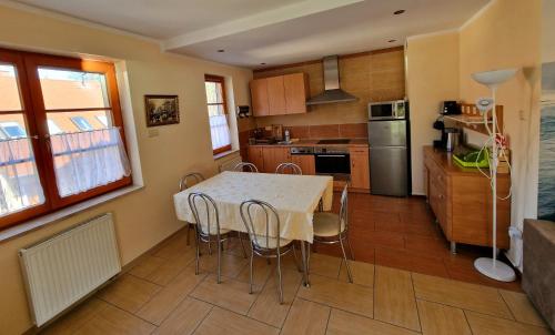 a kitchen with a table and chairs in a room at Apart 5 by Villmaris in Pobierowo