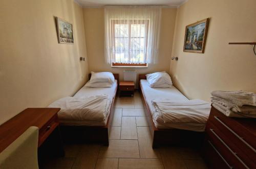a room with two beds and a window at Apart 5 by Villmaris in Pobierowo