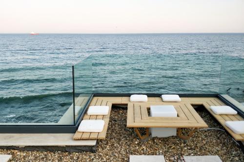Beach Villa Varna - cosiness 4 meters from the sea في مدينة فارنا: طاولة وكراسي مع المحيط في الخلفية