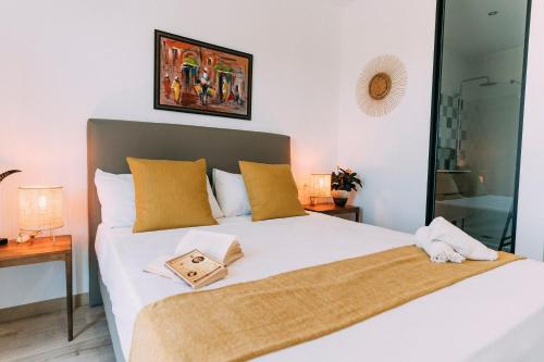 a bedroom with a large white bed with yellow pillows at L'Hotelet del Delta - adults in Deltebre