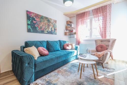 - un salon avec un canapé bleu et une table dans l'établissement Apartman Adriana, à Banja Koviljača
