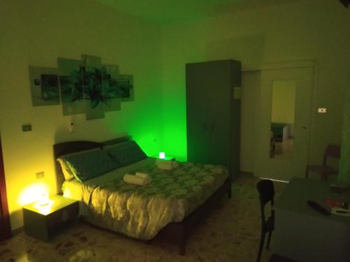 1 dormitorio verde con 1 cama y 1 silla en All inBasilicata Bed & Breakfast, en Baragiano