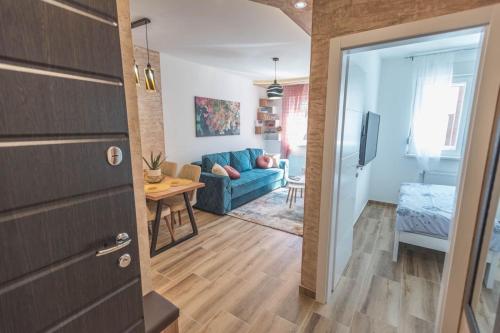 - un salon avec un canapé bleu et une table dans l'établissement Apartman Adriana, à Banja Koviljača
