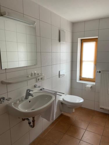 a white bathroom with a sink and a toilet at Der Limes Kipfenberg in Kipfenberg