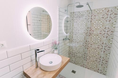 a white bathroom with a sink and a mirror at L'Hotelet del Delta - adults in Deltebre