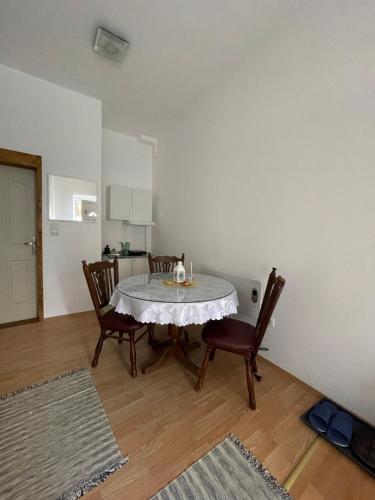 a dining room with a white table and chairs at Apartman studio Lusi 1 in Subotica
