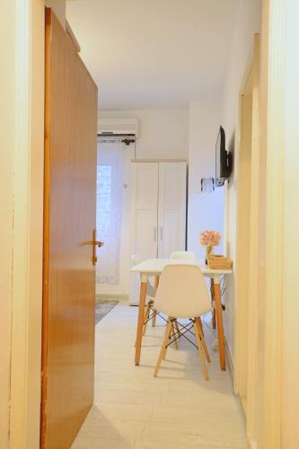 a dining room with a table and a white chair at Old Town Experience - Studio Apartment in Budva