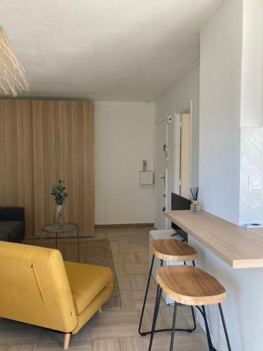 - un salon avec un canapé jaune et une table dans l'établissement Appartement CUBA NICE, à Saint-Laurent-du-Var