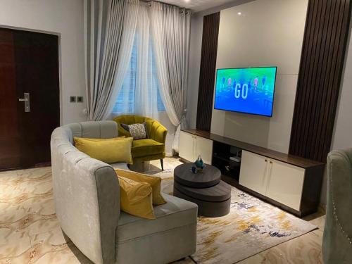 a living room with a couch and a television at Blue Bell Suites in Lekki