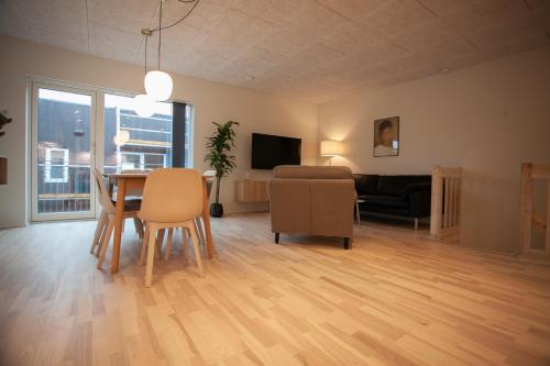 a living room with a table and chairs and a couch at New / 4 BR / Cozy / Walks / Hoyvík in Tórshavn