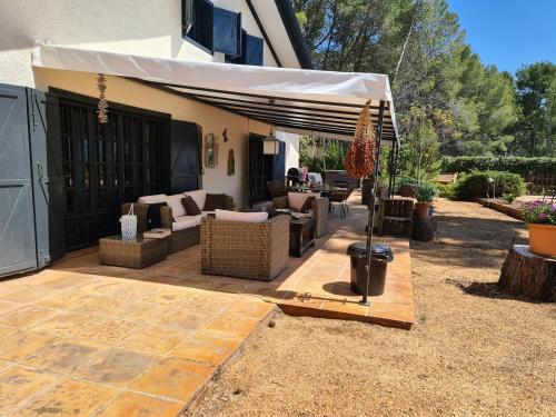 a patio with an umbrella and a couch and chairs at B&B Finca la Yuca "Un paraíso en Ontinyent" in Ontinyent