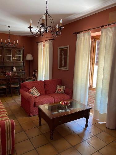 a living room with a red couch and a coffee table at Casa Rural Mirador del Castillo in Almodóvar del Río