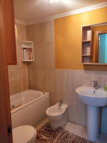 a bathroom with a sink and a toilet and a tub and sink at Mi dulce hogar in Porriño