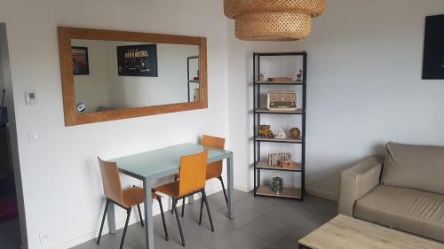 un salon avec une table, des chaises et un canapé dans l'établissement Appartement T3 lumineux et au calme. Wifi,Netflix et parking gratuit., à Hendaye