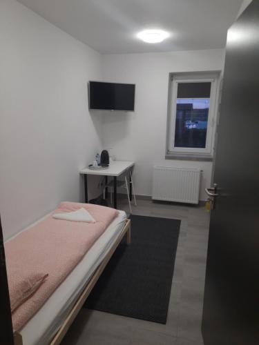 a bedroom with a bed and a table and a window at Noclegi u Andrzeja in Gdańsk