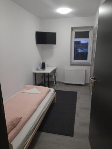a bedroom with a bed and a table and a window at Noclegi u Andrzeja in Gdańsk