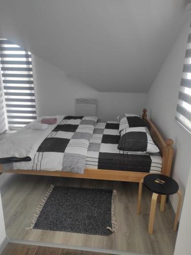 a bed with a black and white comforter in a room at Prenoćište Ljiljana 2 in Livno