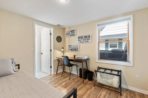 a bedroom with a bed and a desk and a window at Perfect Location Walk to MSU Campus High End Mattresses Fast Wi-Fi in East Lansing