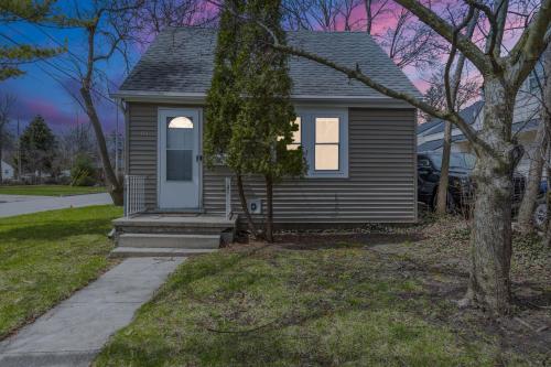 a small house with a porch and a tree at Perfect Location Walk to MSU Campus High End Mattresses Fast Wi-Fi in East Lansing