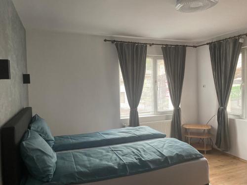 1 dormitorio con 1 cama y una ventana con cortinas en Guest House Simona en Sapareva Banya