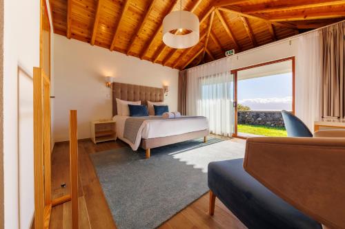 een slaapkamer met een bed en een woonkamer bij Quinta da Magnólia AR in Urzelina