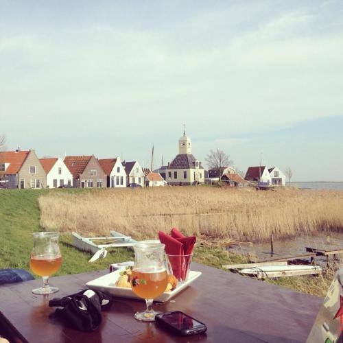 a table with two glasses of beer and a plate of food at Lovely holiday house in Durgerdam in Amsterdam