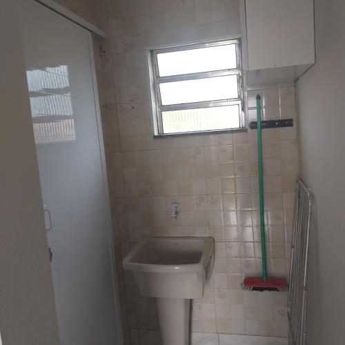 a small bathroom with a sink and a window at Morada do Sol in Ilha Comprida