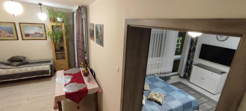 een kamer met een woonkamer met een televisie en een tafel bij Apartament Toruń Starówka - Ducha in Toruń