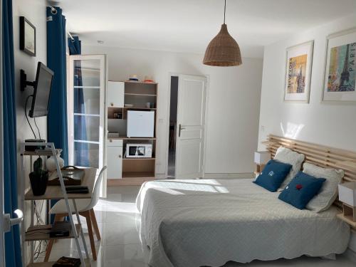 1 dormitorio con 1 cama grande con almohadas azules en Magnifique villa avec piscine, en Villeneuve-lès-Maguelonne