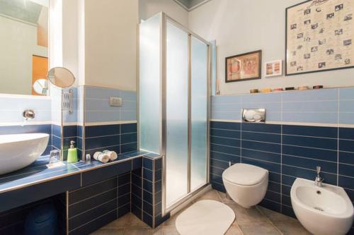 W wyłożonej niebieskimi kafelkami łazience znajduje się umywalka i toaleta. w obiekcie B&B la casa di Arturo w Turynie
