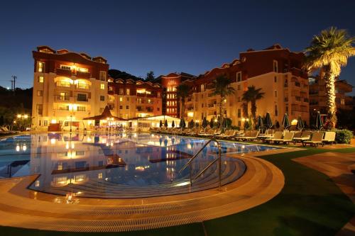 a large pool in front of a building at night at Club Aida in Marmaris