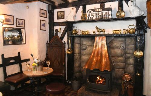 a living room with a fireplace and a table and a table sidx sidx at The Black Boy Inn in Caernarfon