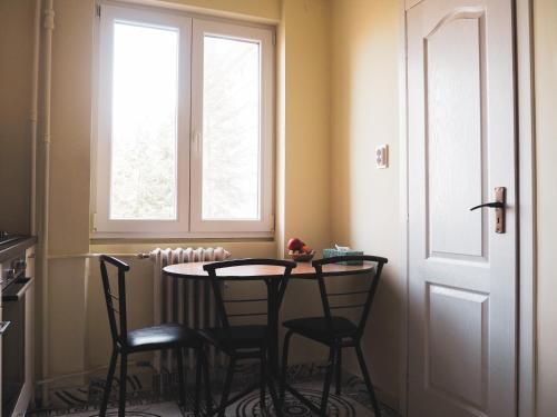 a table and chairs in a room with a window at Modern Room With A Great Sunrise - close to the center - in Timişoara
