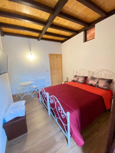 a bedroom with a large bed with a red bedspread at Guardian's House in Monopoli