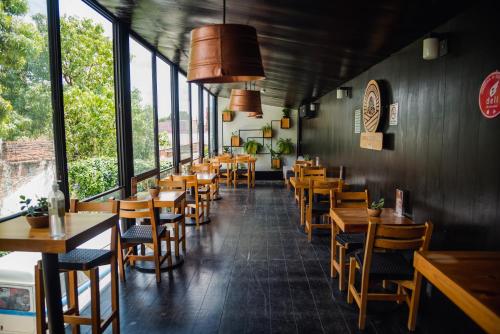 a restaurant with wooden tables and chairs and windows at Hotel Momotus in Tuxtla Gutiérrez